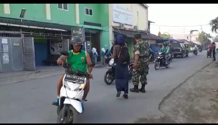 Koramil 12/HP Kodim 0201 BS Membantu Anak Sekolah Menyeberang Jalan