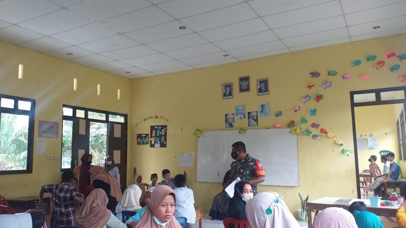 Babinsa Koramil 04/Perawang Serda Venus Luberto Dampingi Anak Vaksinasi