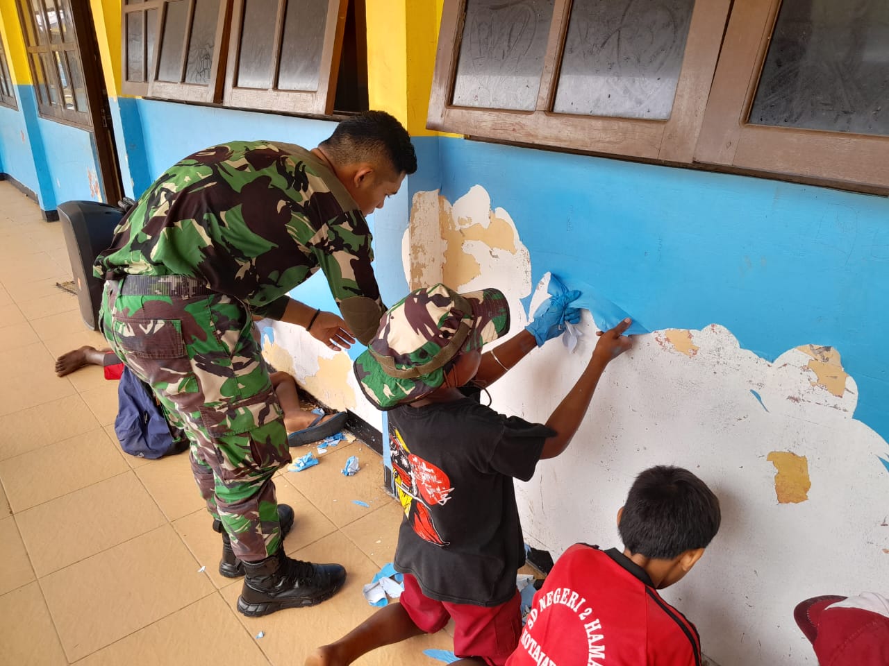 Semangat dan Keceriaan Murid SD Skouw Mabo Bersama Personel Satgas Yonif 122/TS Perbaiki Dan Perbaharui Cat Gedung Sekolah