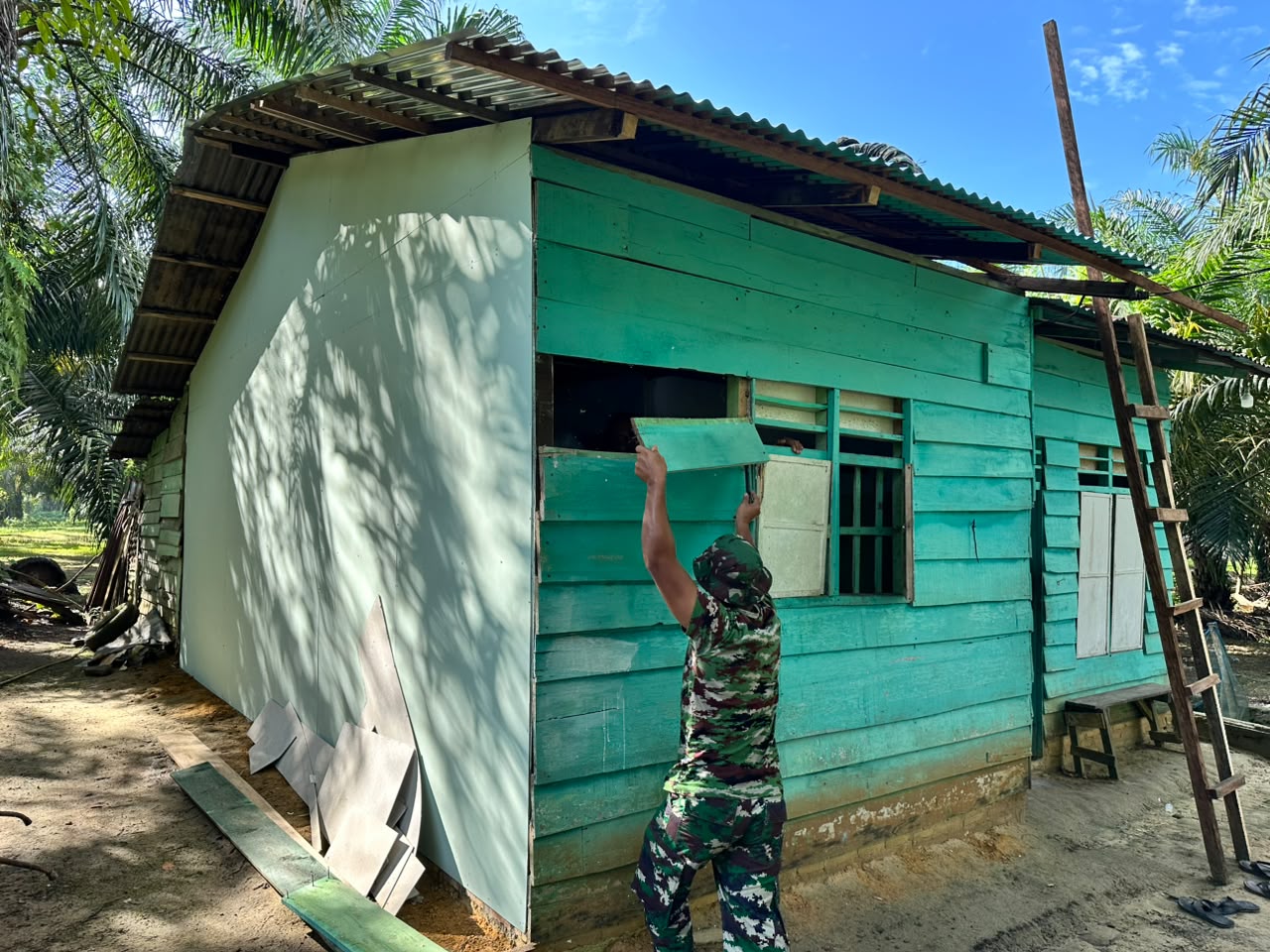 Prajurit Satgas TMMD ke-130 Kodim 0209/Labuhanbatu Pembongkaran Papan Bagian Depan Rumah Edi Harahap